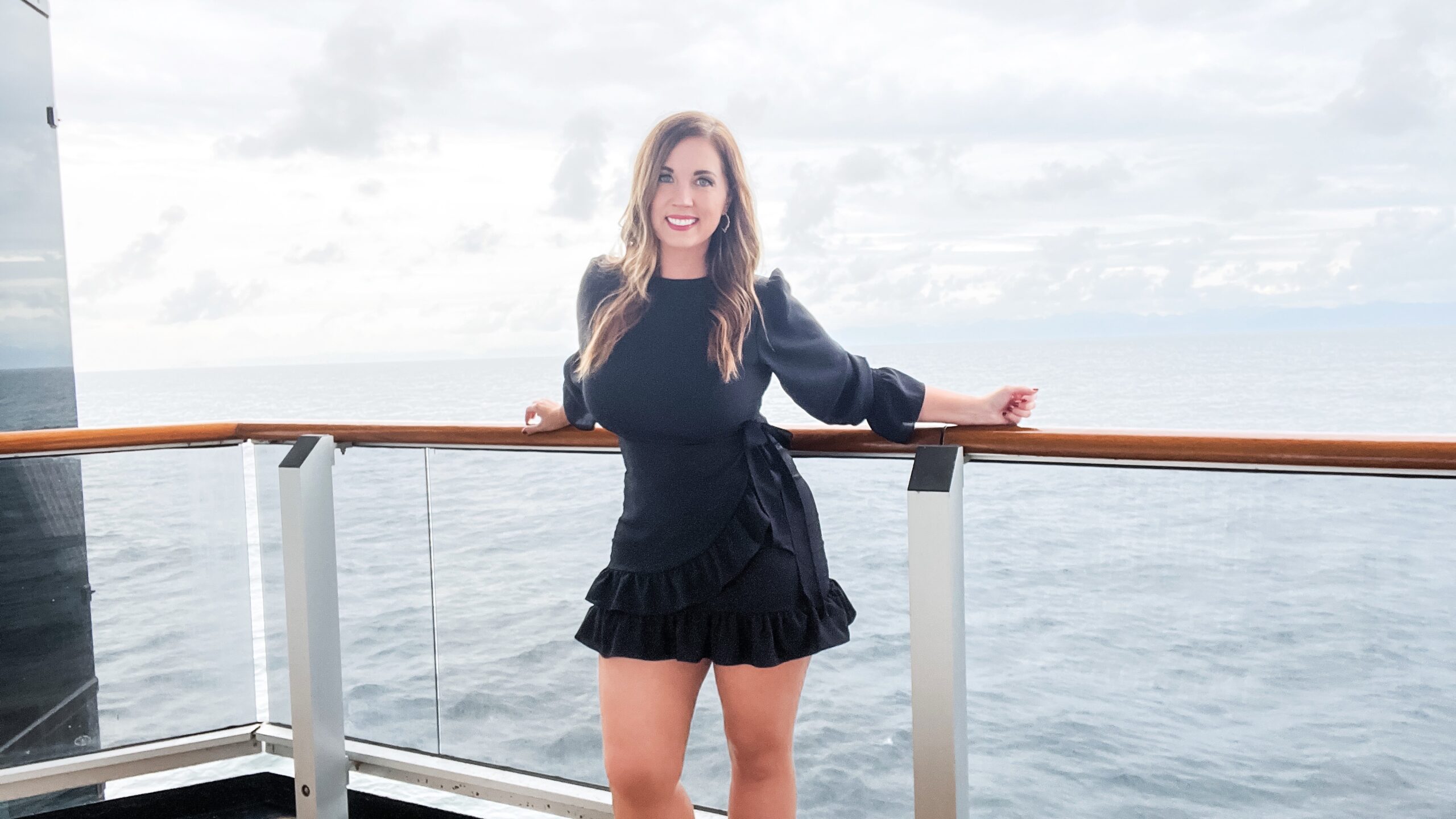 A woman poses on a cruise ship balcony at sea in Alaska