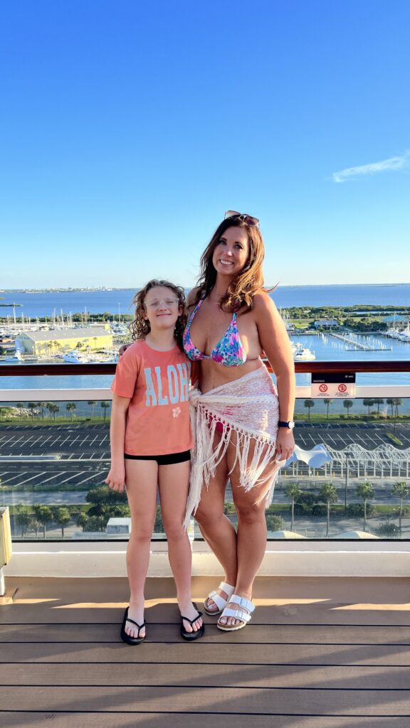 A woman and her daughter post from the top deck of a Carnival cruise ship docked at Port Canaveral in Florida