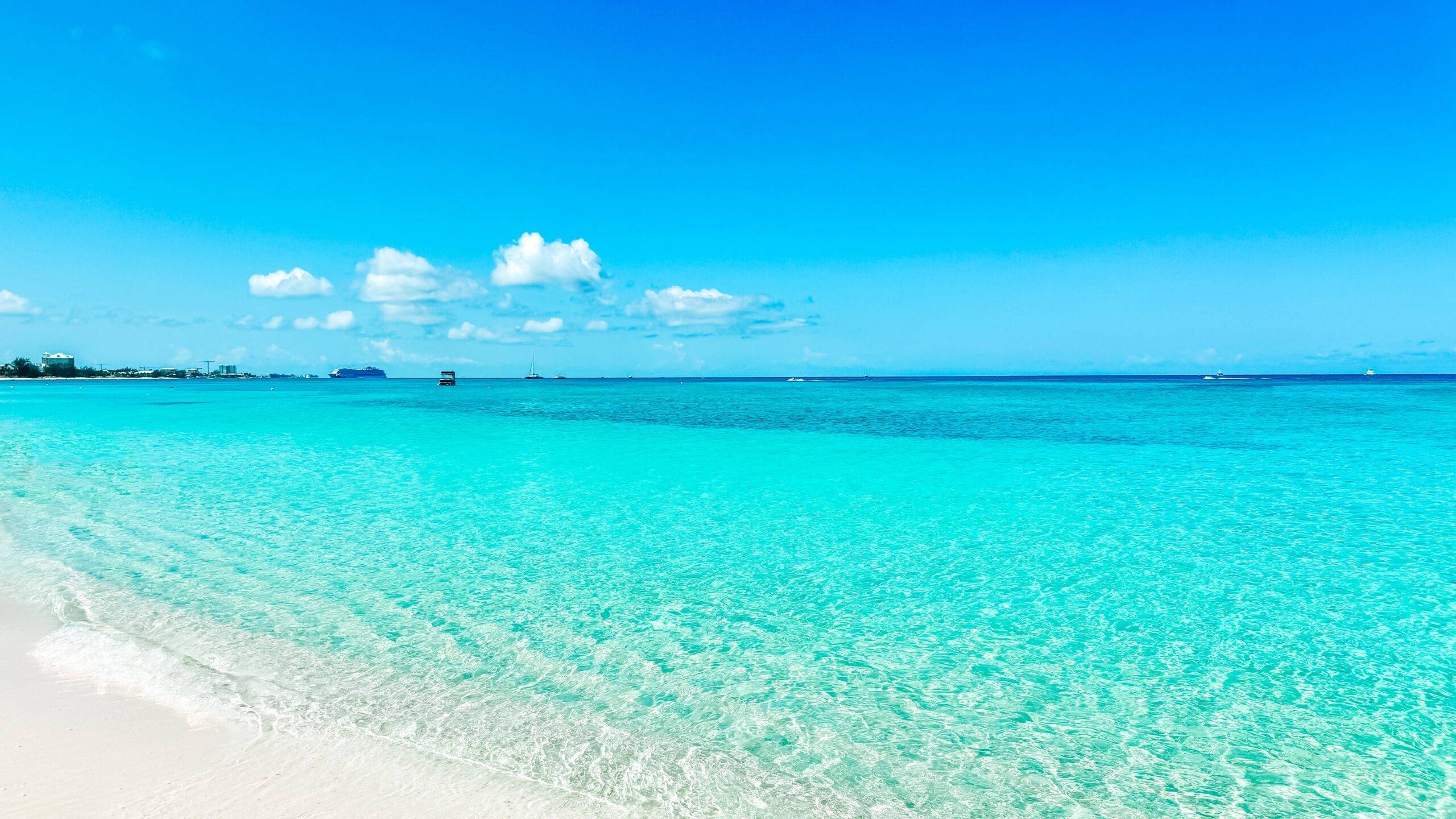 Cruise ships are seen in the distance from the sands of Seven Mile Beach in George Town, Grand Cayman