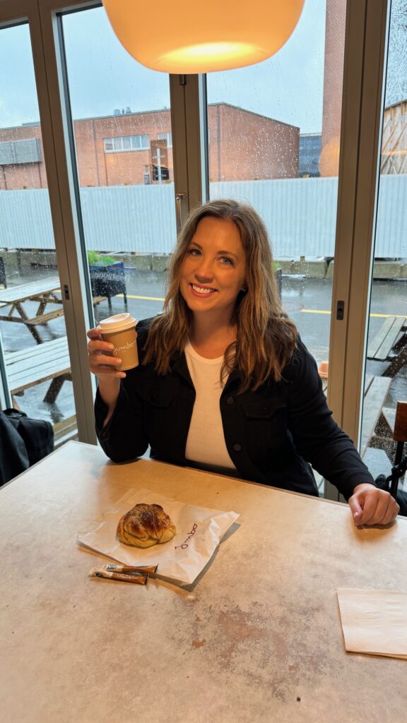 A woman enjoys a coffee and pastry inside a cafe in Aarhus, Denmark.
