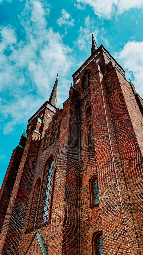 A stunning view of a historic brick cathedral with two tall spires