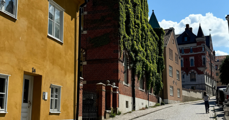 A close-up view of a cobblestone street in Visby, showcasing colorful historic buildings.